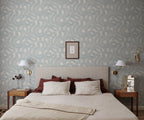 Zen wallpaper by Sandberg in blue looping print behind a bed with red and ivory linens and wall sconces