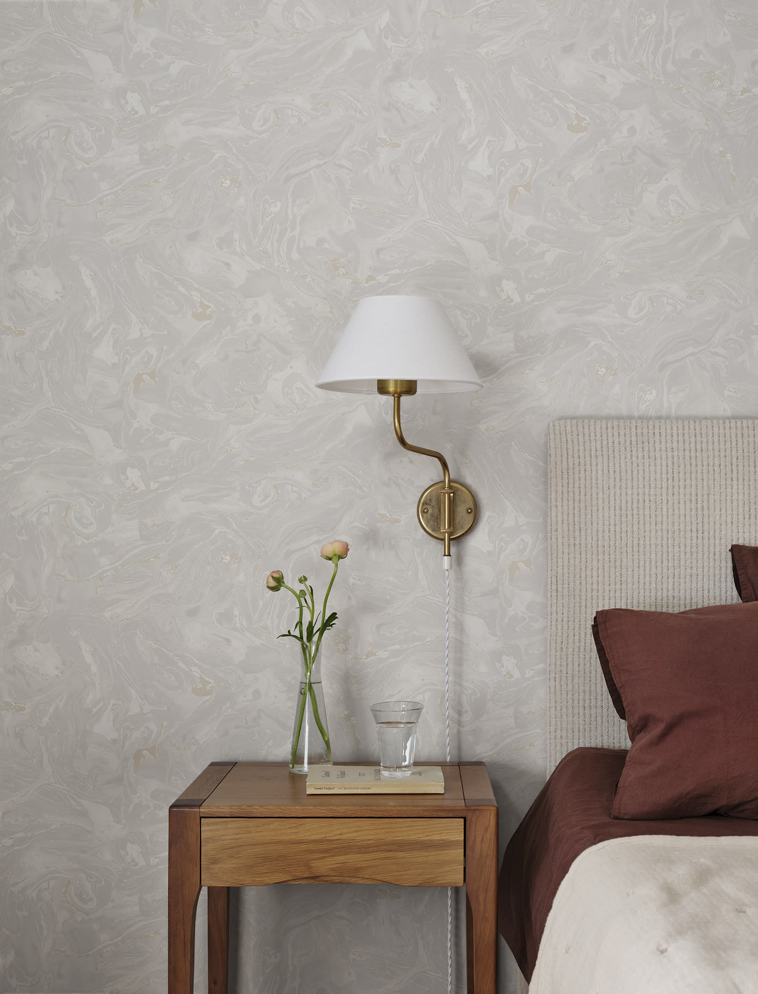 Soft grey Marion marbled wallpaper by Sandberg beside a bed with brass wall lamp and oak nightstand