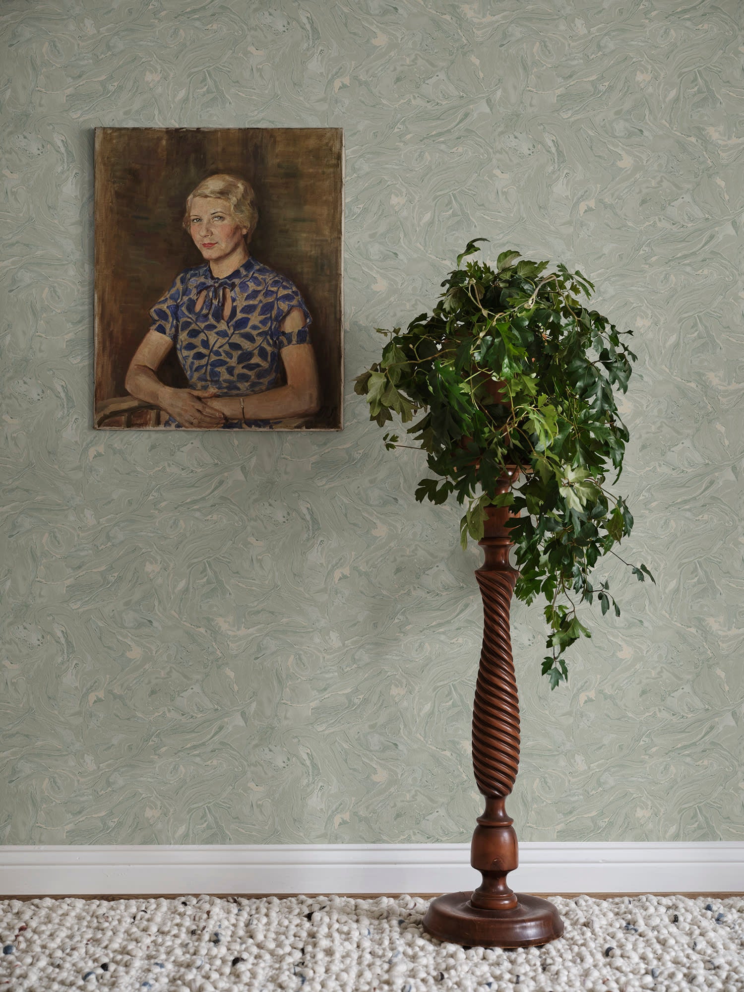 Sage-green Marion marbled wallpaper by Sandberg with a vintage portrait and a topiary on a turned wooden stand