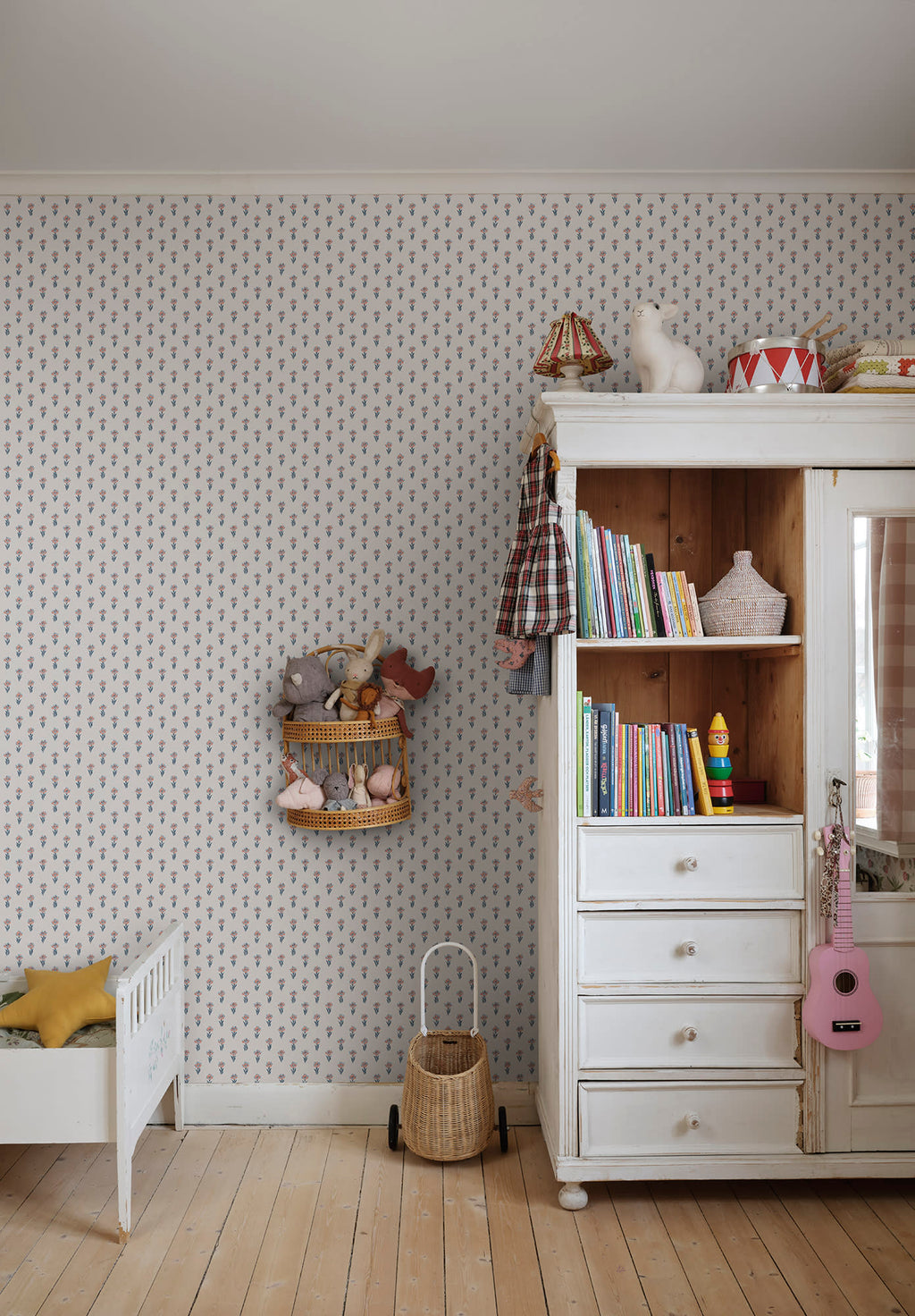 Betty wallpaper by Sandberg in a nursery, tiny blue floral sprig pattern beside a white wardrobe and toddler bed