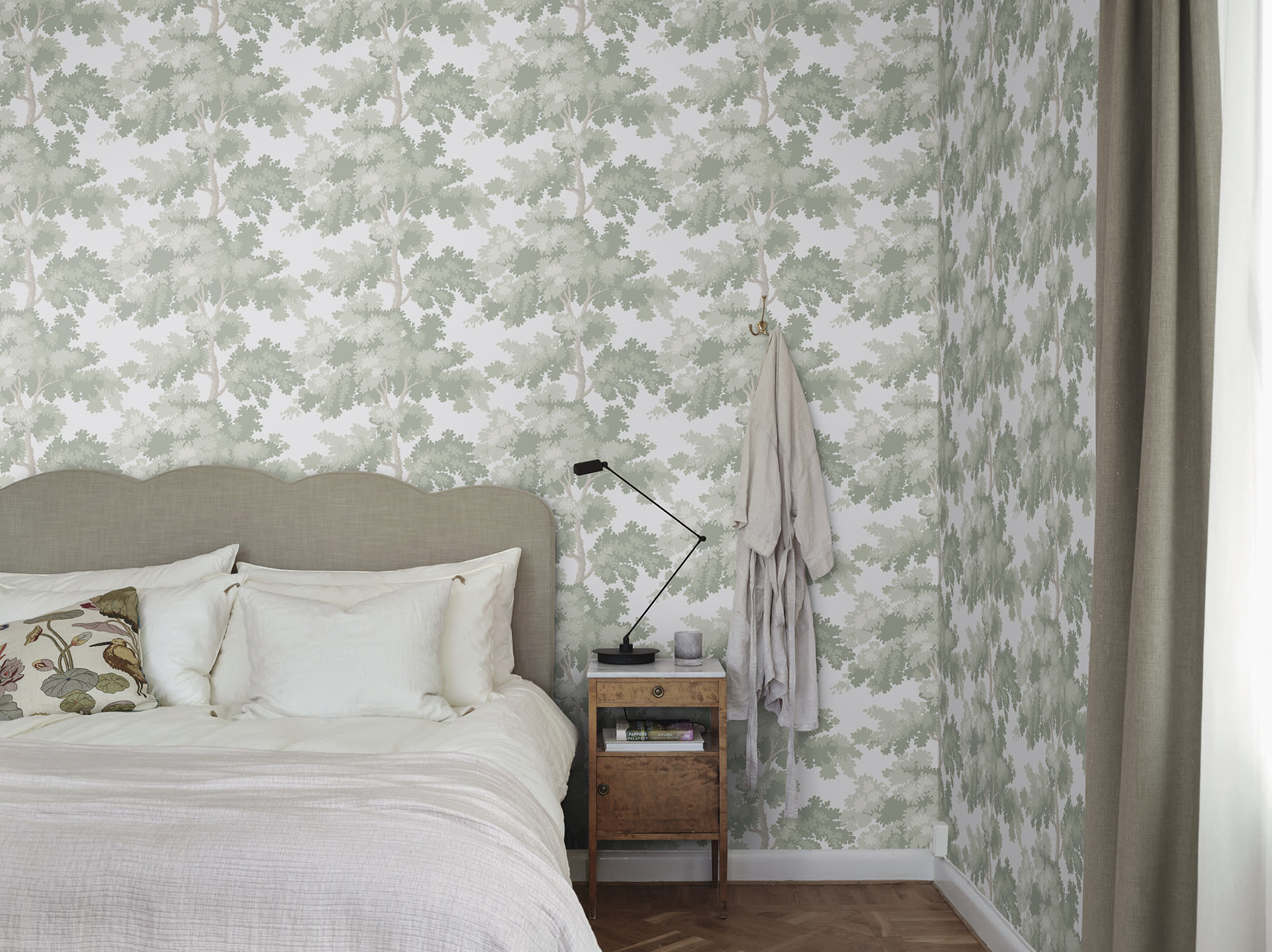 Raphael wallpaper by Sandberg in Green - botanical design, behind a bed with white linen