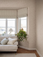 Beige Karolina trailing-leaf wallpaper by Sandberg in a living room with neutral sofa and roman blinds