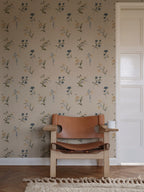 Hanna wallpaper by Sandberg in beige behind a tan leather sling chair on a fringed rug