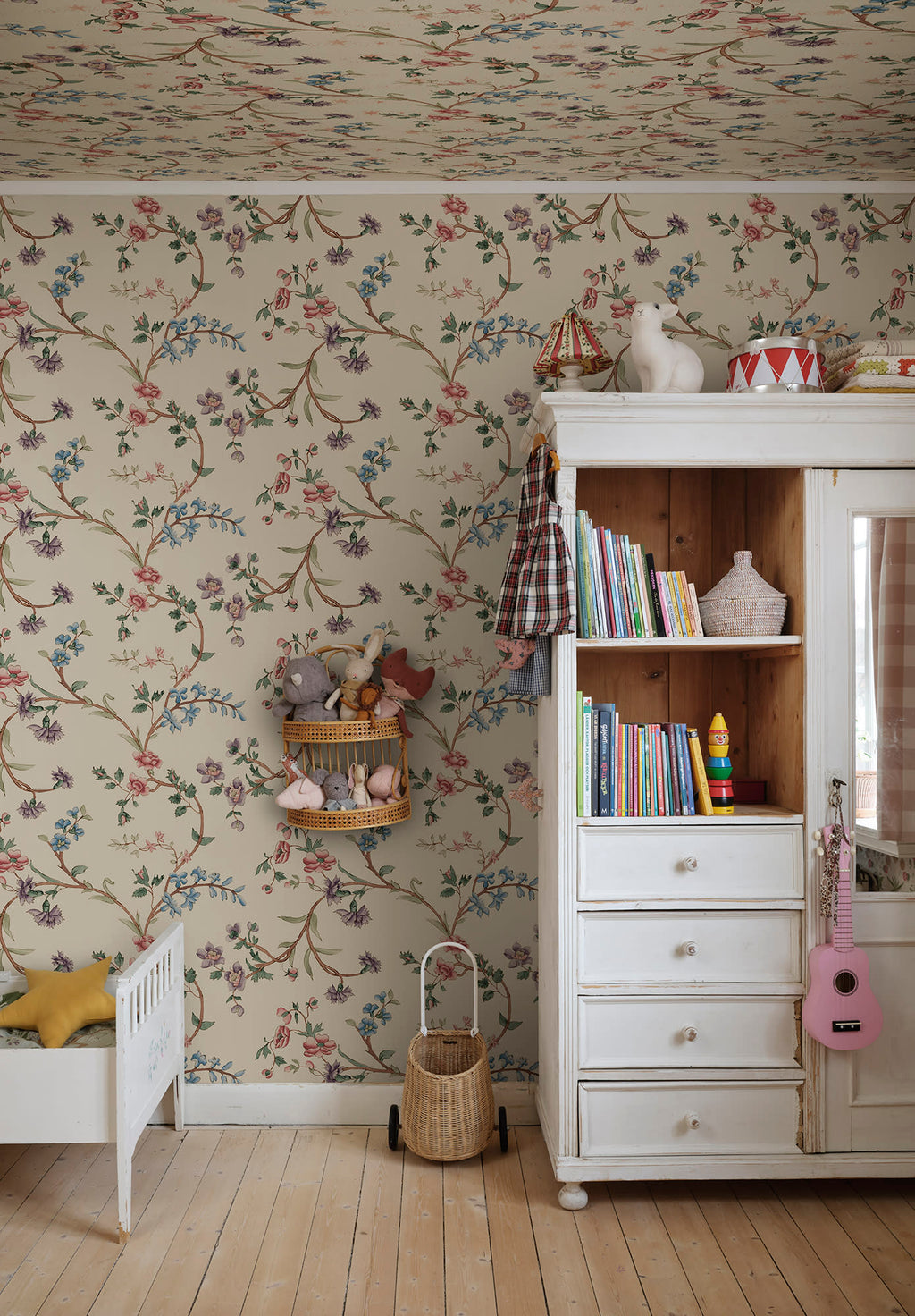 Clara floral mural by Sandberg in a childrens room with white cabinet, toys and timber floor.