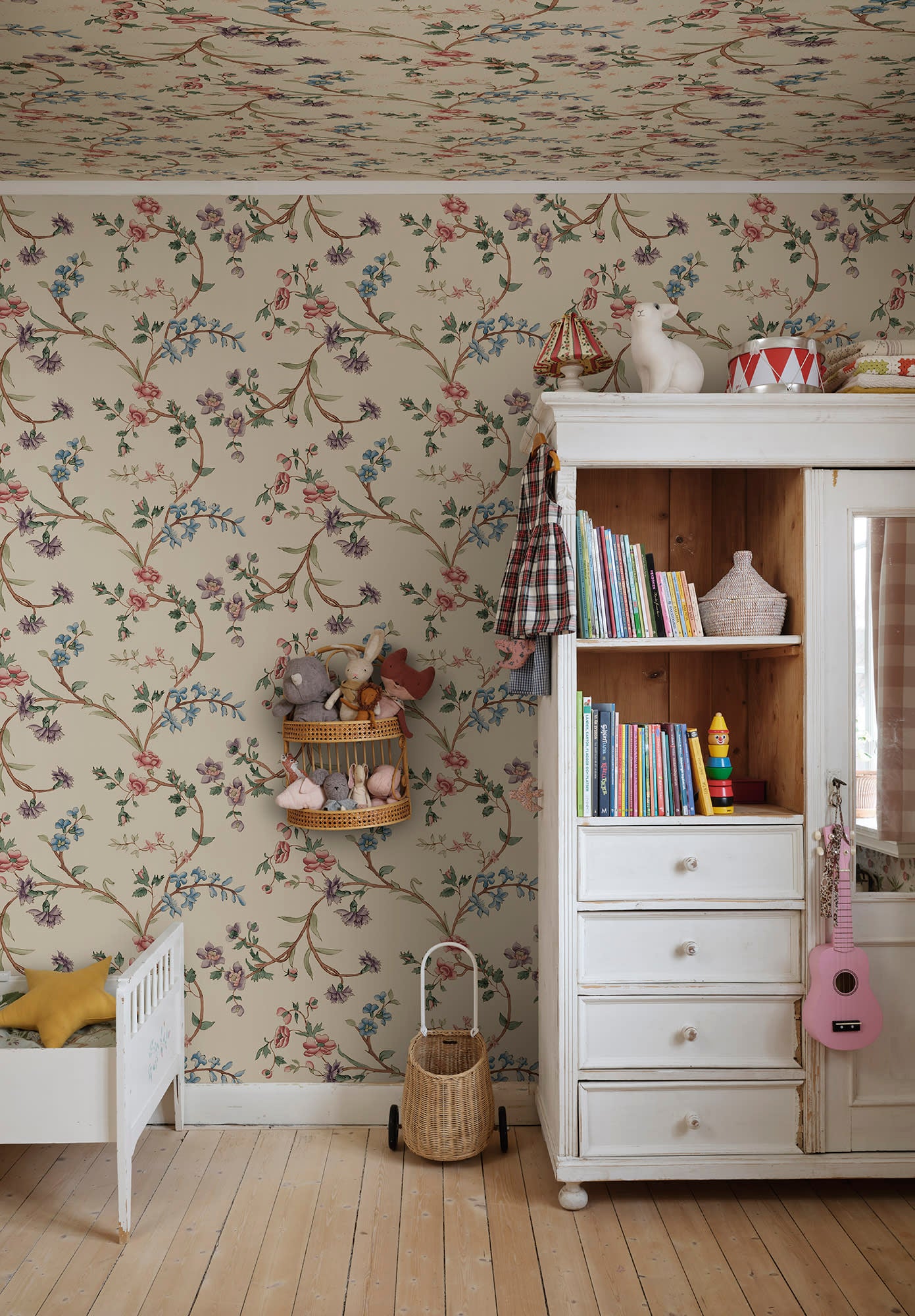 Clara floral mural by Sandberg in a childrens room with white cabinet, toys and timber floor.