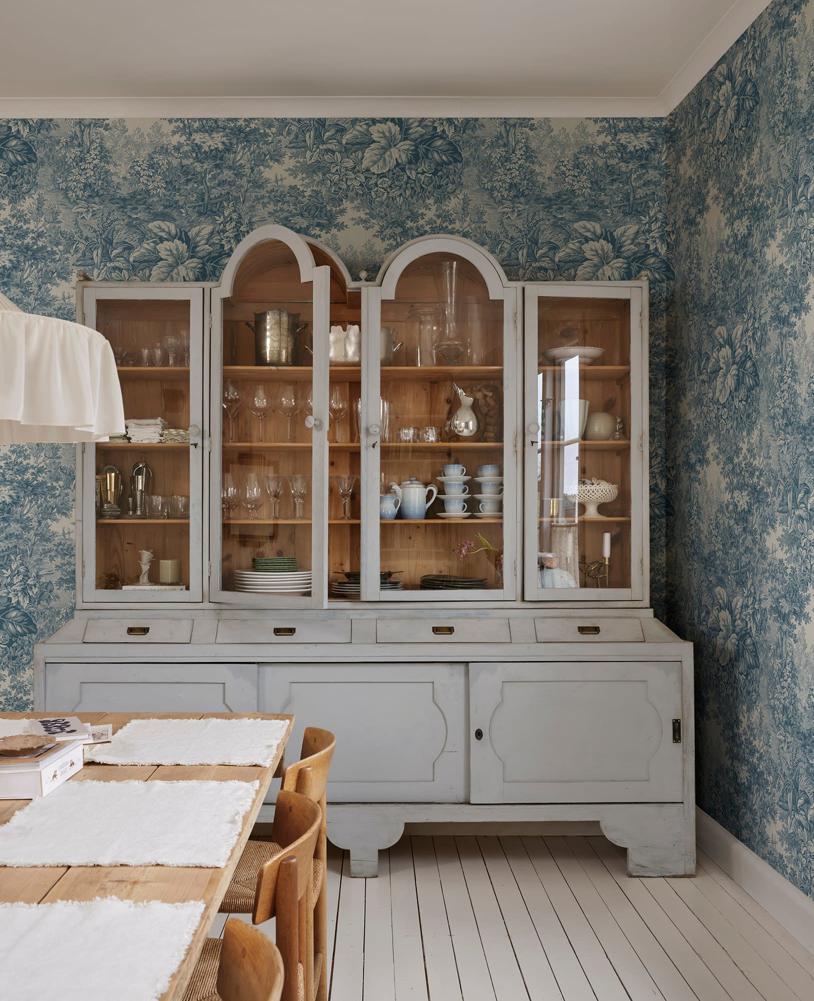 Forest Toile wall mural by Sandberg in a dining room behind a grey glazed dresser, blue woodland toile pattern