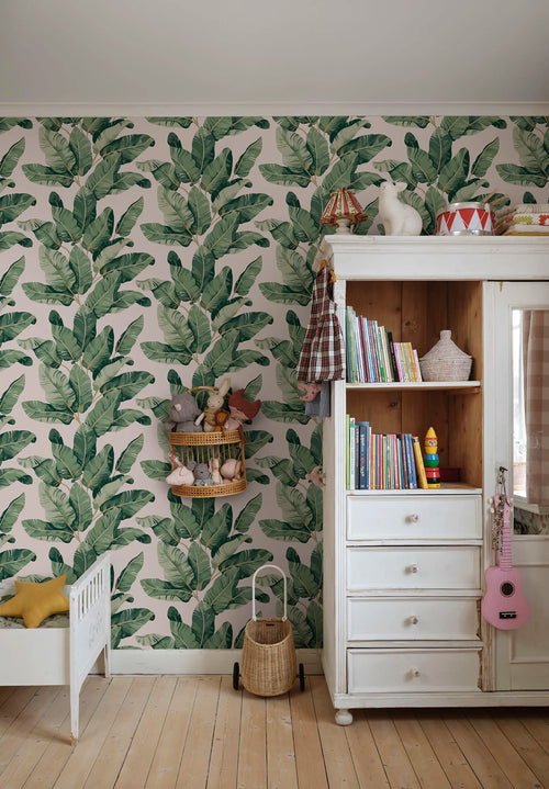 Tom Palms wallpaper by Sandberg, green banana leaves on pale pink, styled in a childs room with white furniture