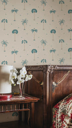 Milo Palms wallpaper by Sandberg in teal on cream, styled in a bedroom above a dark wood dresser with white orchids