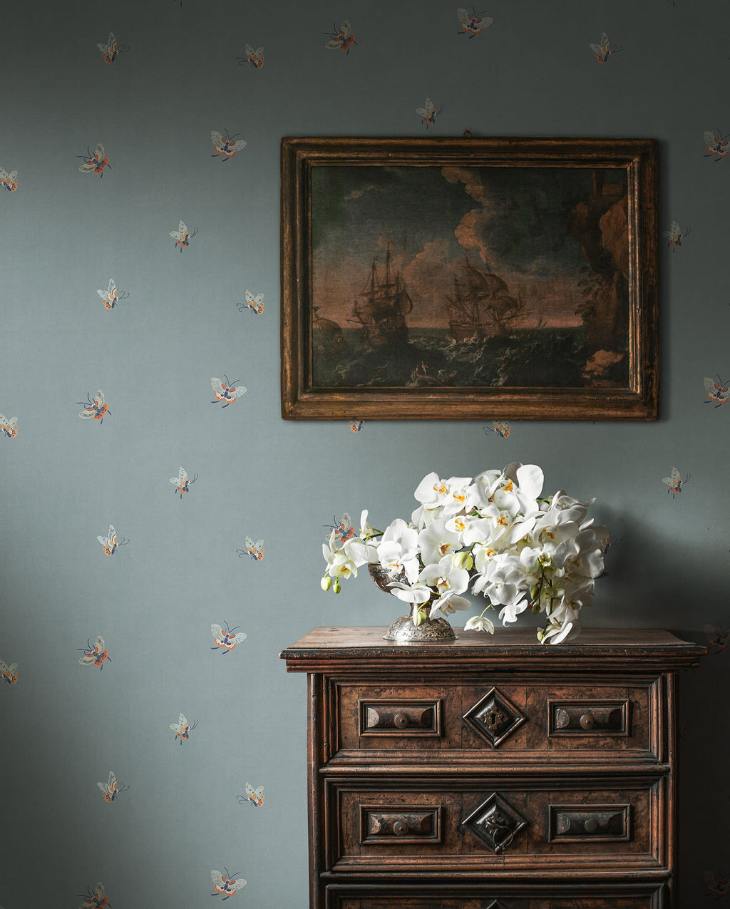 Butterflies wallpaper by Sandberg in Misty Blue shown on a wall in a styled room