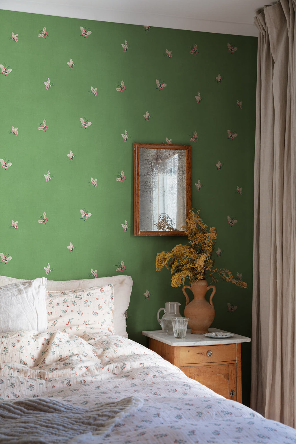 Butterflies wallpaper by Sandberg in Green shown on a wall in a styled room