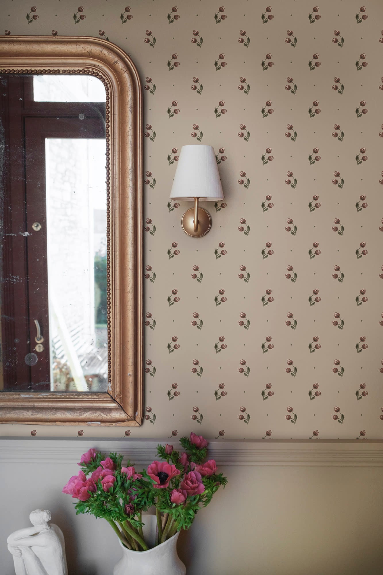 Siv wallpaper by Sandberg in burgundy, close-up beside a gilt mirror and brass wall sconce