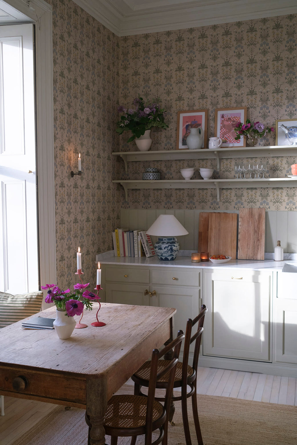 Maj wallpaper by Sandberg in beige in a country kitchen with open shelving, candles and a rustic timber table