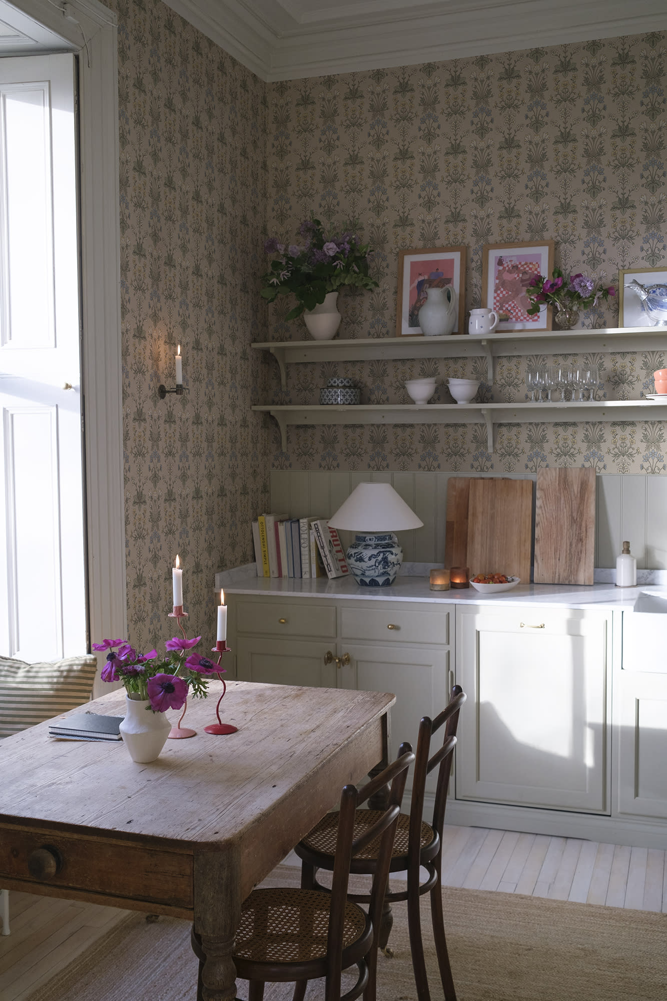 Maj wallpaper by Sandberg in beige in a country kitchen with open shelving, candles and a rustic timber table
