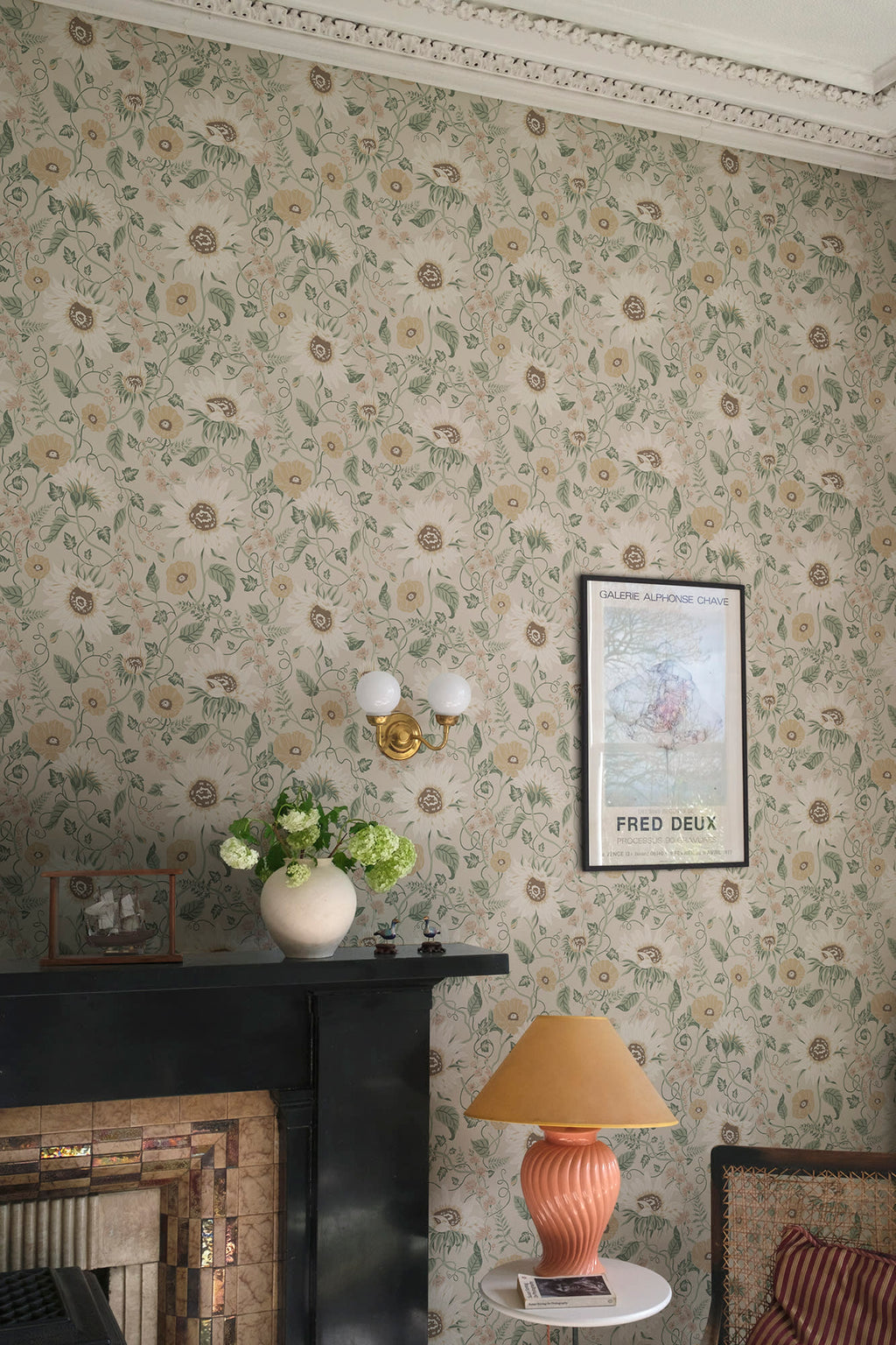 Solveig wallpaper by Sandberg in neutral tones styled in a living room with a black fireplace and coral lamp