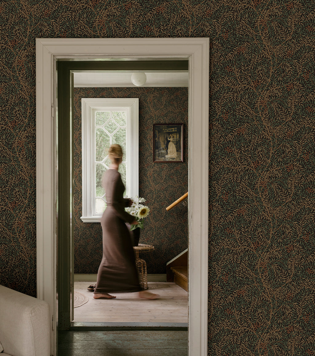 Simon wallpaper by Sandberg in dark green in a hallway framing a woman in a doorway by a window