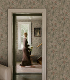 Ulla wallpaper by Sandberg in sage tones styled across a period hallway with a woman walking past a window