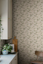 Emilie wallpaper by Sandberg in beige on a kitchen wall beside cabinetry, a chopping board and potted plant