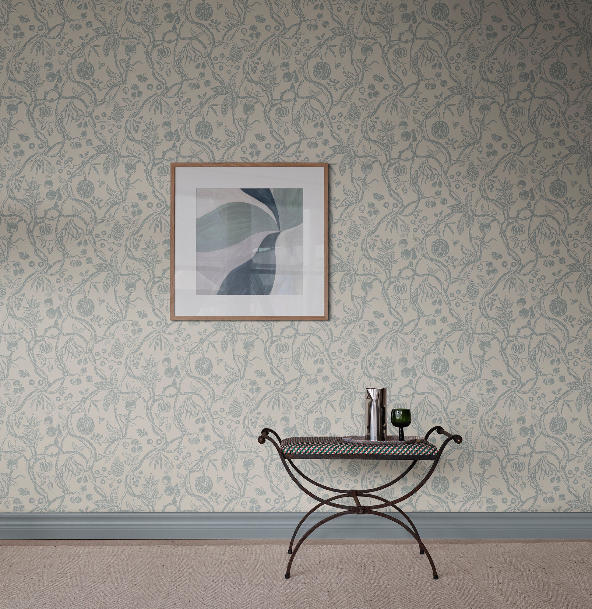 Tree of Life wallpaper by Sandberg in soft blue-grey, styled on a wall with framed abstract art above an iron bench