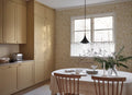 Tree of Life wallpaper by Sandberg in ochre-gold, styled in a kitchen-diner beside a window with timber table and chairs
