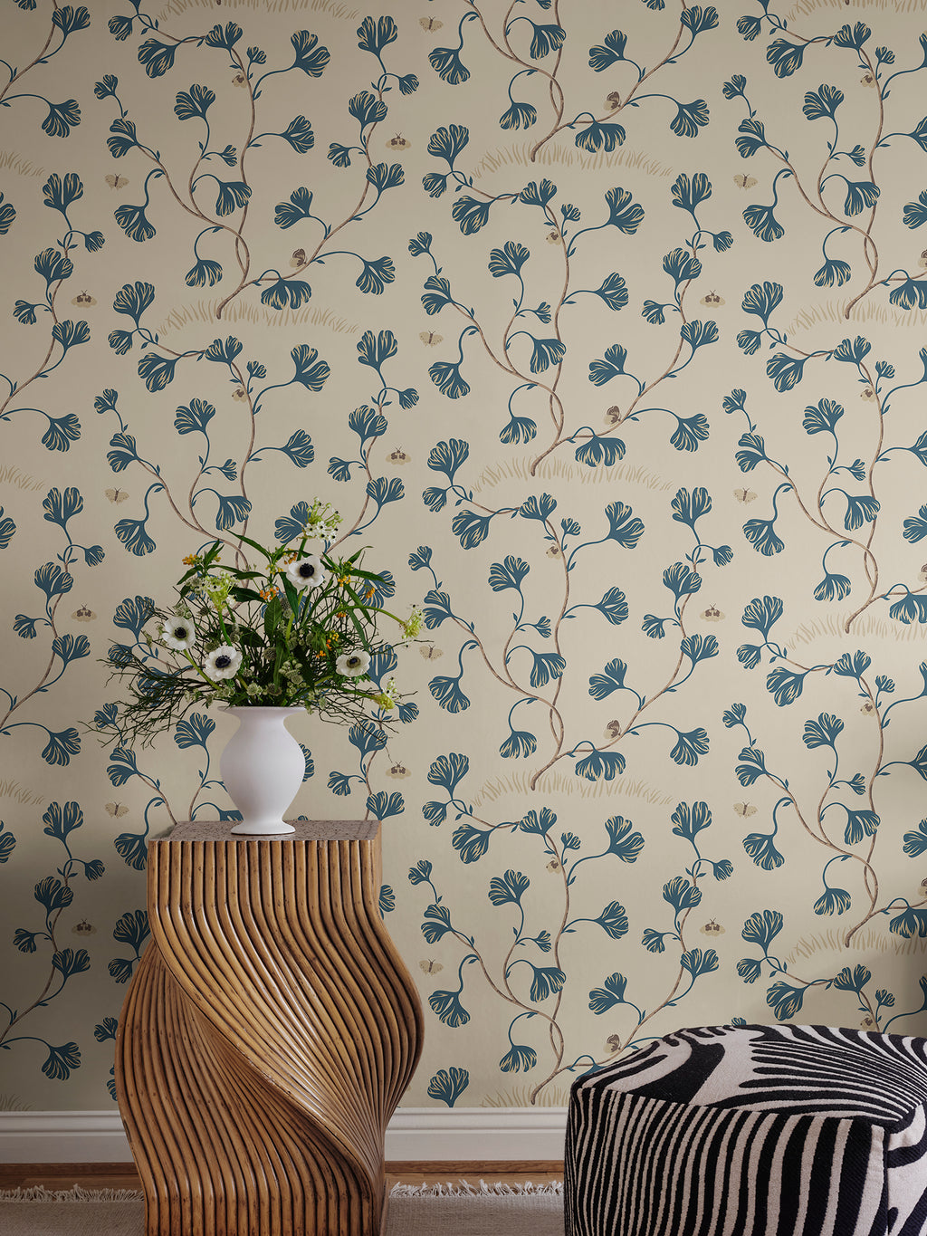 Ebba wallpaper by Sandberg in cream behind a sculptural timber side table topped with a vase of wildflowers