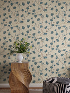 Ebba wallpaper by Sandberg in cream behind a sculptural timber side table topped with a vase of wildflowers