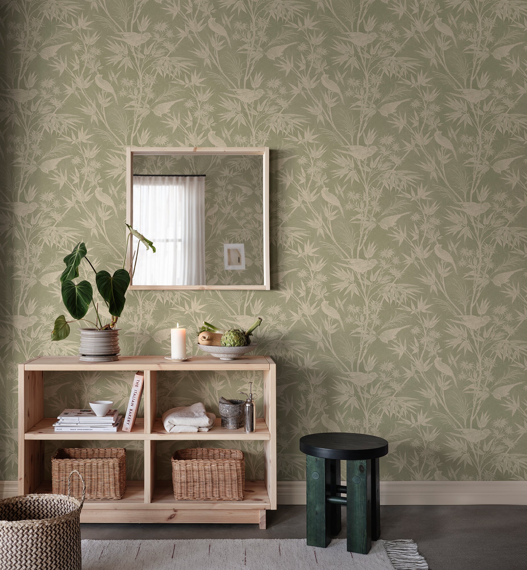 Celeste wallpaper by Sandberg in sage green in an entryway behind a timber console with mirror, plant and baskets