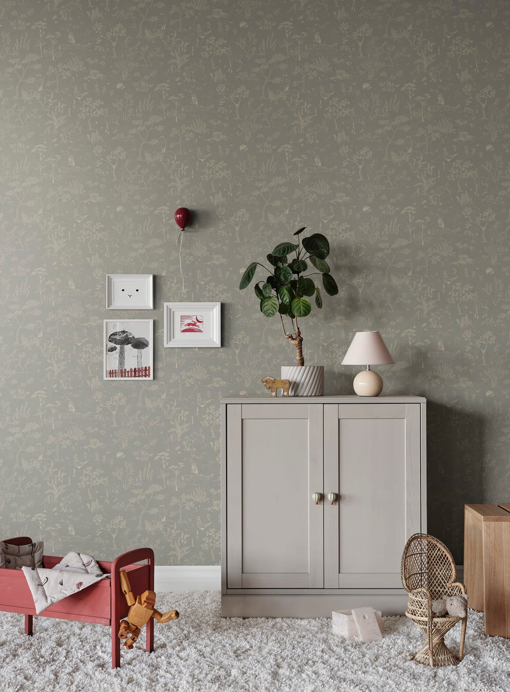 Hollie wallpaper by Sandberg in grey-green woodland print in a nursery with grey cabinet and red toddler bed