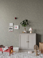 Hollie wallpaper by Sandberg in grey-green woodland print in a nursery with grey cabinet and red toddler bed
