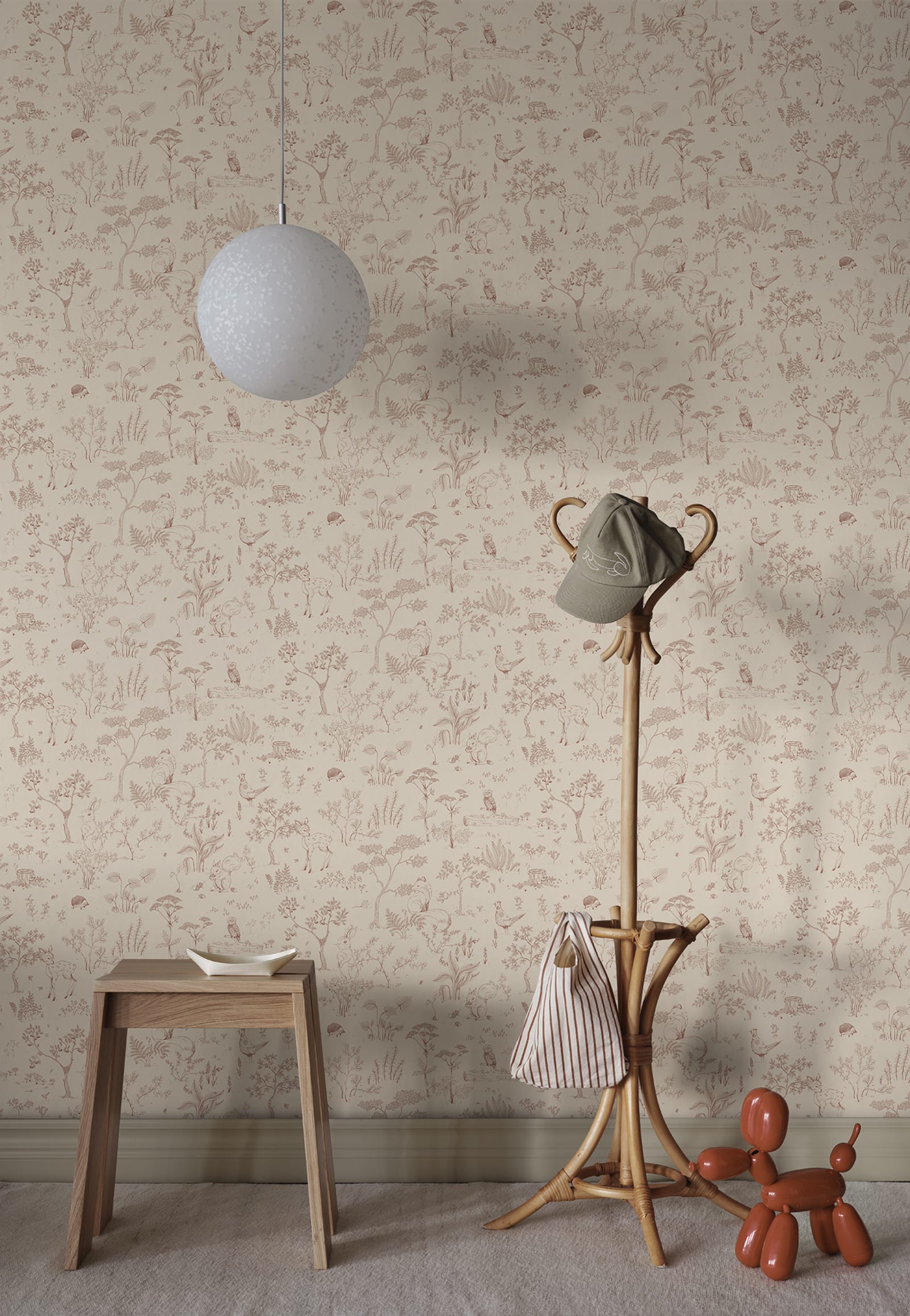 Hollie wallpaper by Sandberg in dusky pink woodland print in a hallway with wooden stool and rattan coat stand