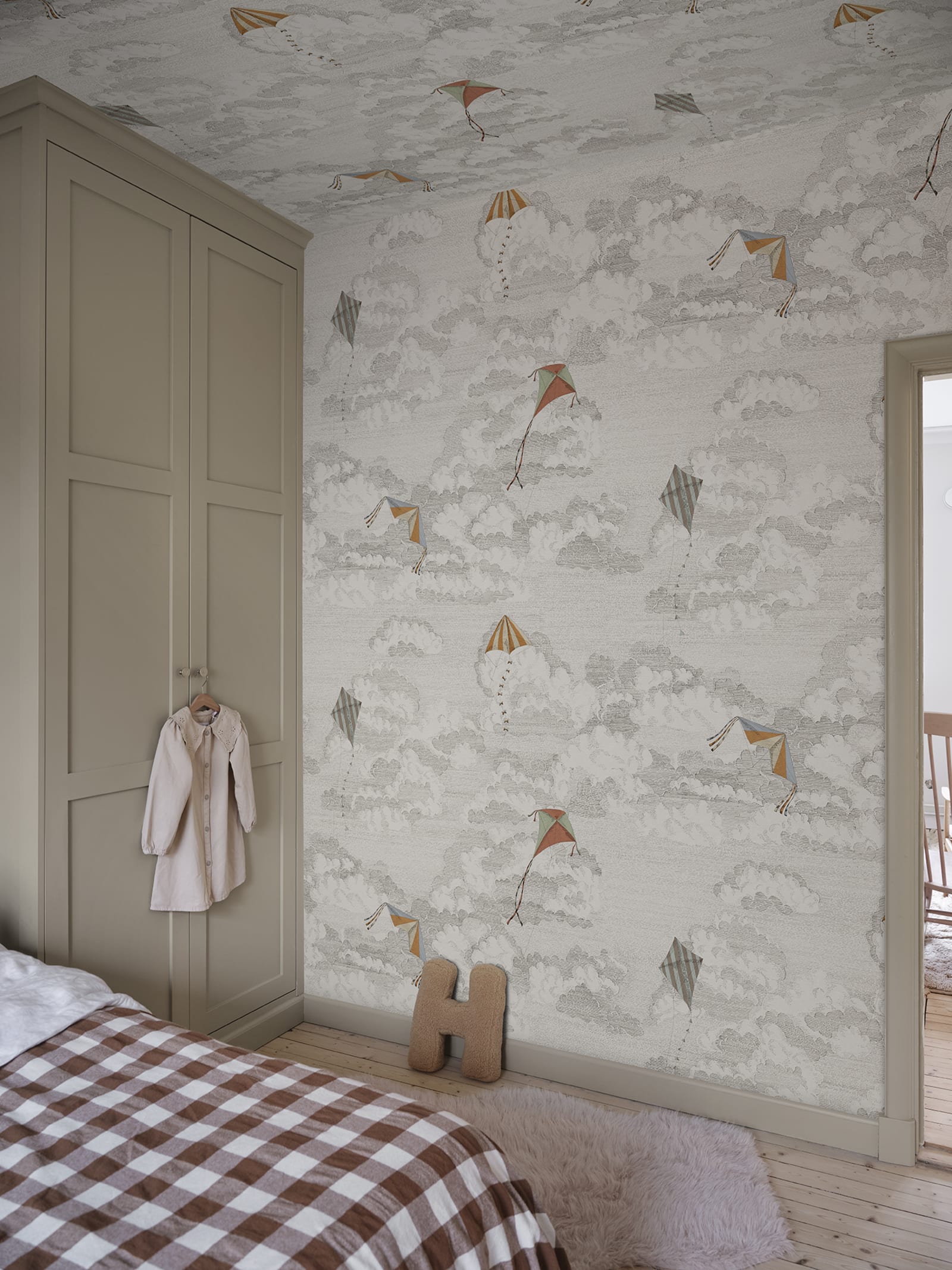 Bonnie & Kites wall mural by Sandberg in cream behind a wavy mirror in a childs room with wooden toys