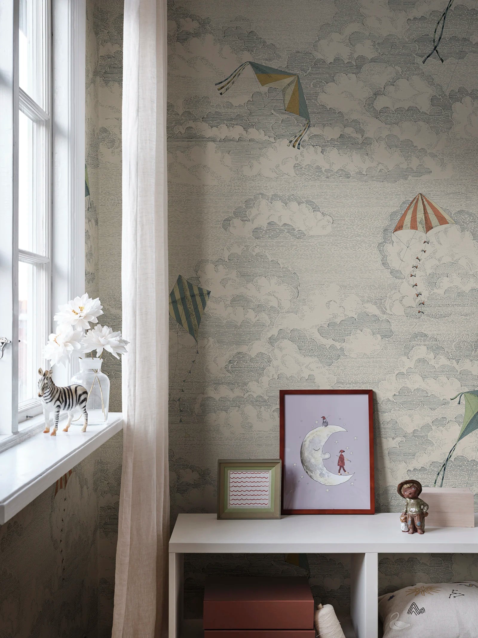 Bonnie & Kites wall mural by Sandberg in blue-grey styled in a nursery beside a window with a zebra figurine