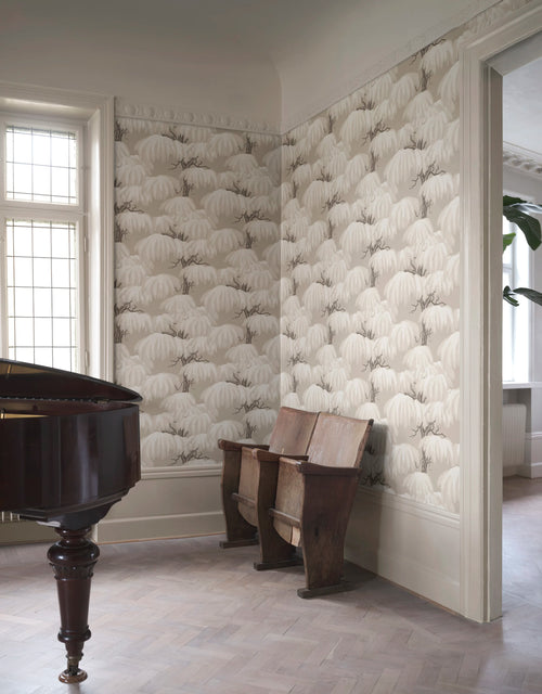 Alba willow wallpaper by Sandberg in neutral cream across two walls, mahogany grand piano by a leaded window and wooden bench seats