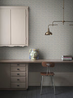 Coral wallpaper by Sandberg in blue-grey, styled in a home office with desk, brass lamp and ceramic head vase