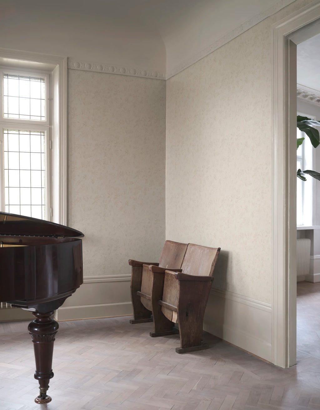 Mila wallpaper by Sandberg in tonal cream, styled in a refined room with a grand piano and antique theatre seats