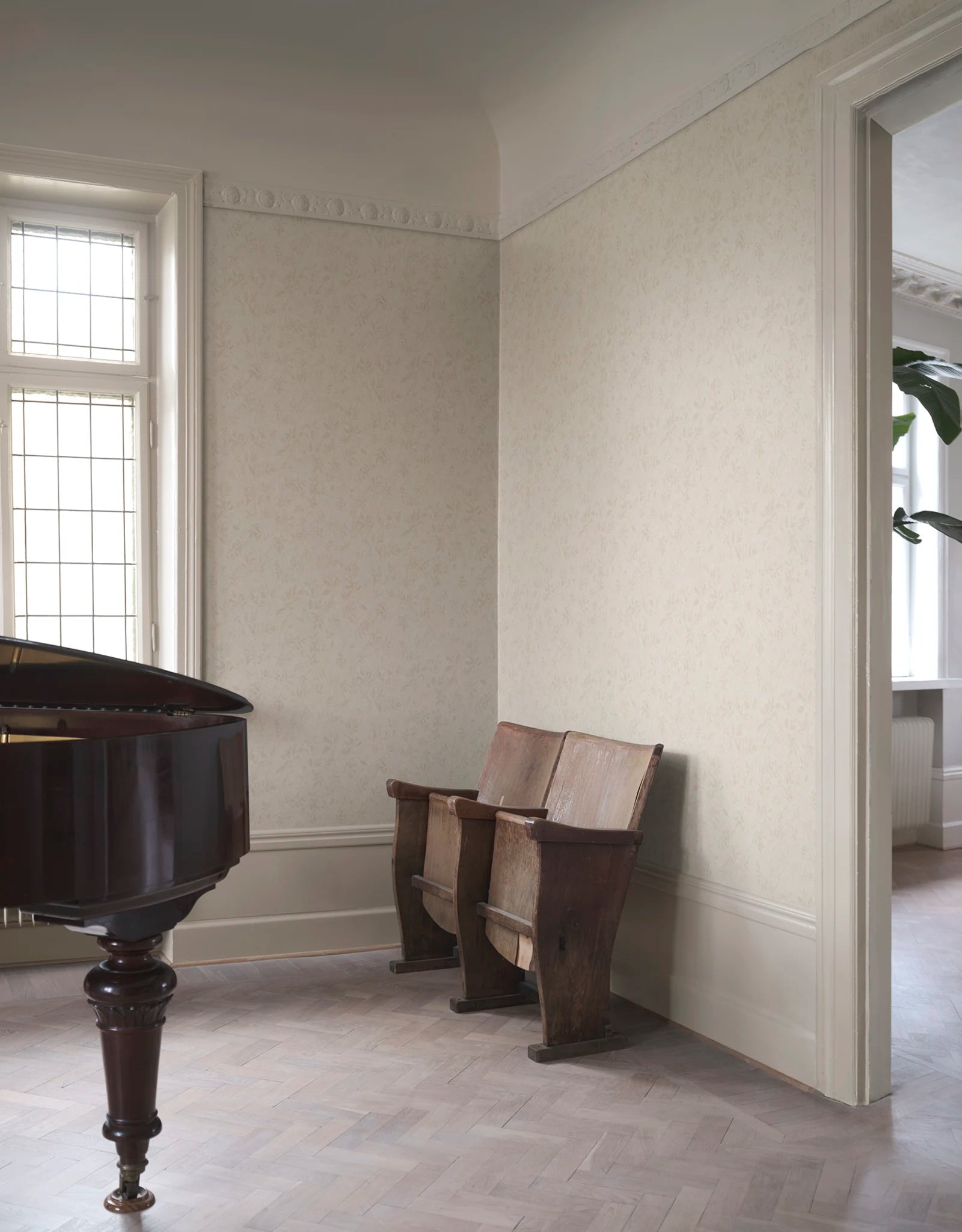 Mila wallpaper by Sandberg in tonal cream, styled in a refined room with a grand piano and antique theatre seats