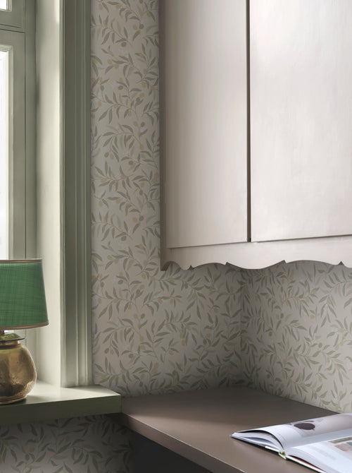 Olivia wallpaper by Sandberg in sage-green olive branches on cream, styled behind a window and kitchen cabinetry with a
