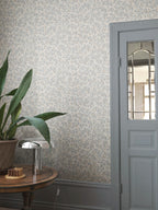 Olivia wallpaper by Sandberg in blue-grey olive branches, styled in an entryway beside a glazed door and snake plant