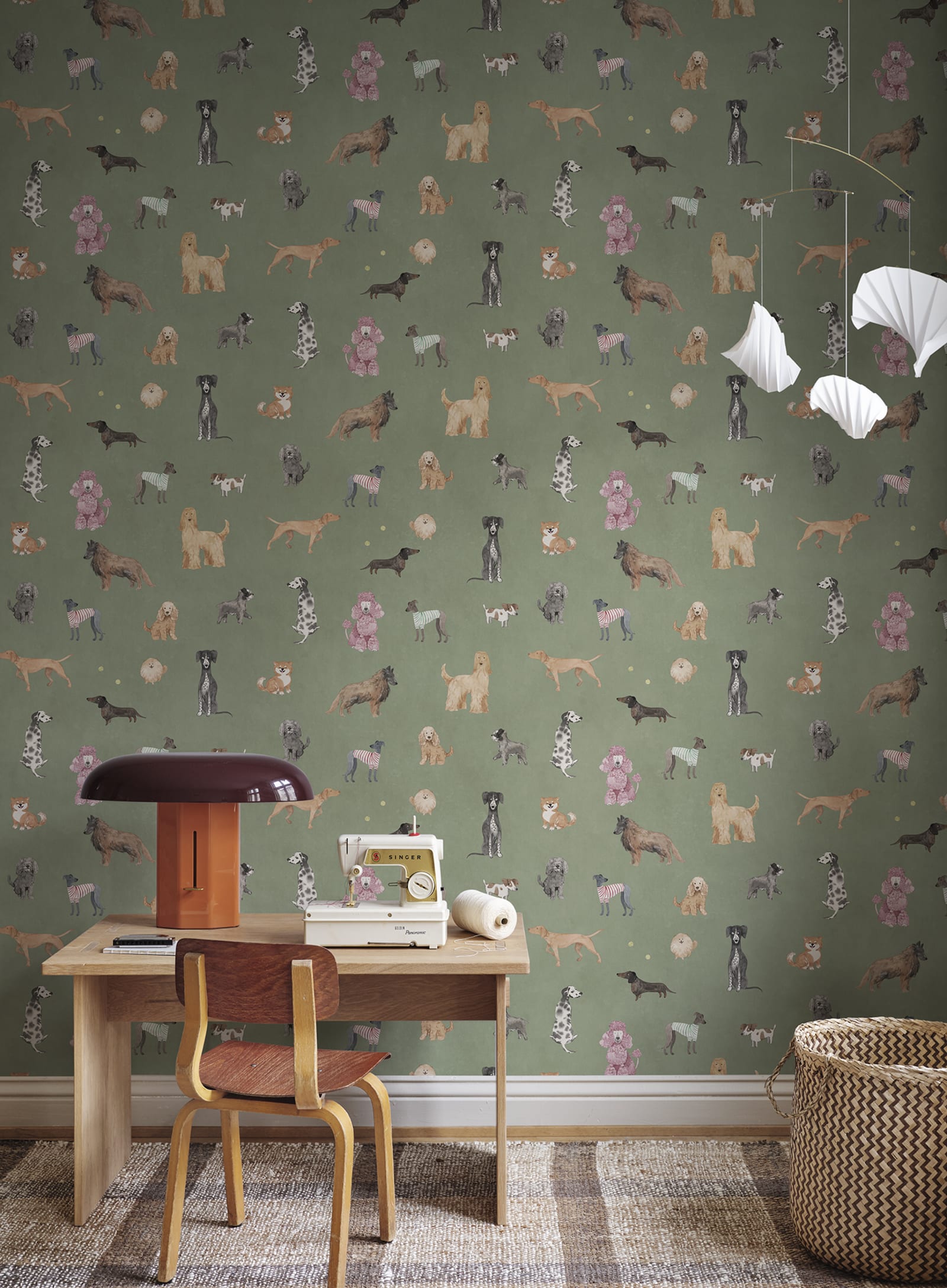 Taiga Dogs & Friends wall mural by Sandberg in sage green styled in a nursery with a desk, sewing machine and mobile