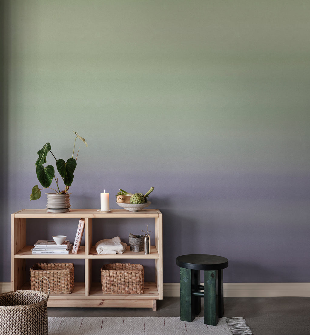 Skymning wall mural by Sandberg, green-to-lilac ombré sky styled behind a pine shelving unit with plants and baskets