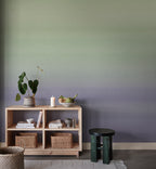 Skymning wall mural by Sandberg, green-to-lilac ombré sky styled behind a pine shelving unit with plants and baskets