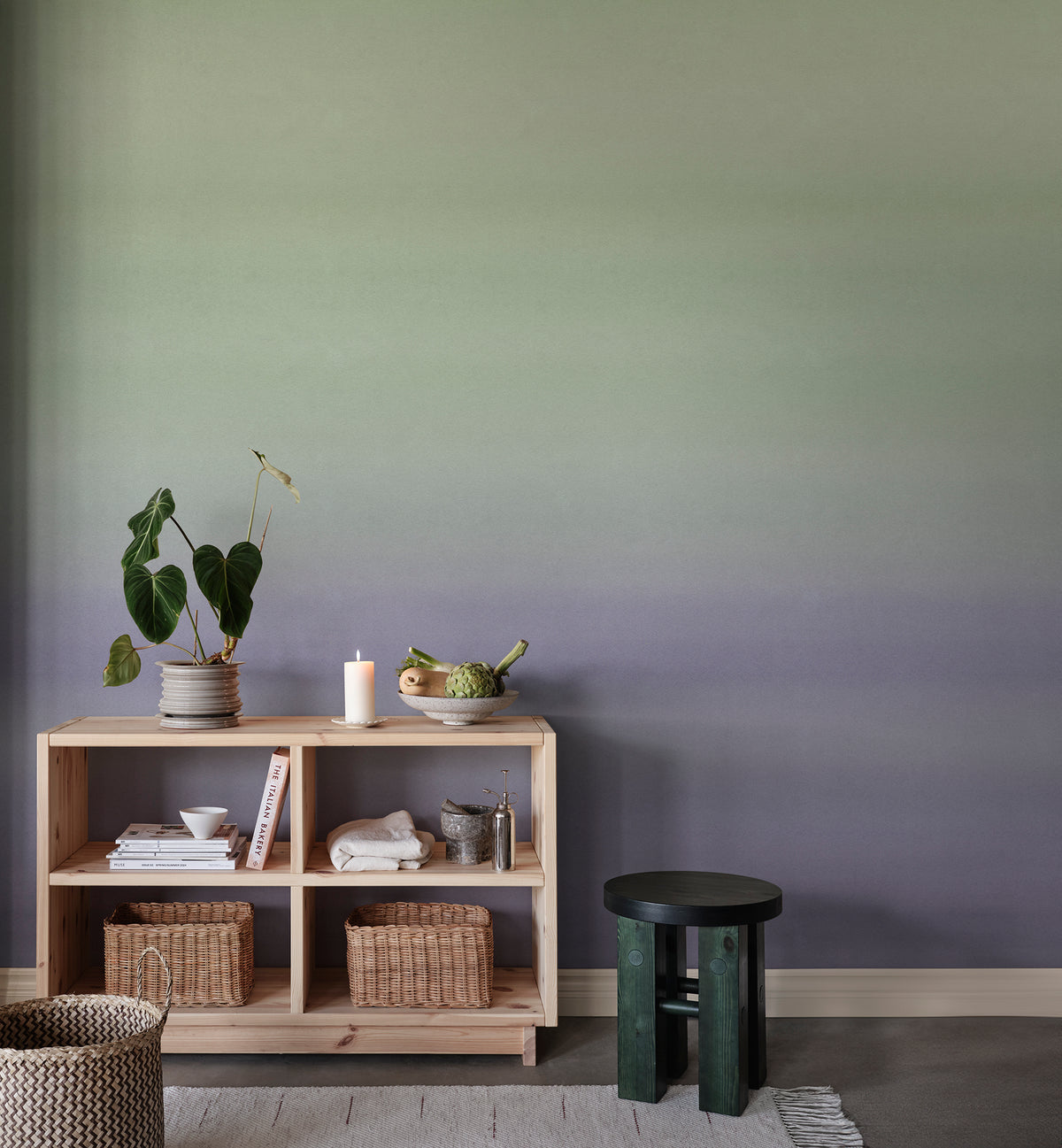 Skymning wall mural by Sandberg, green-to-lilac ombré sky styled behind a pine shelving unit with plants and baskets