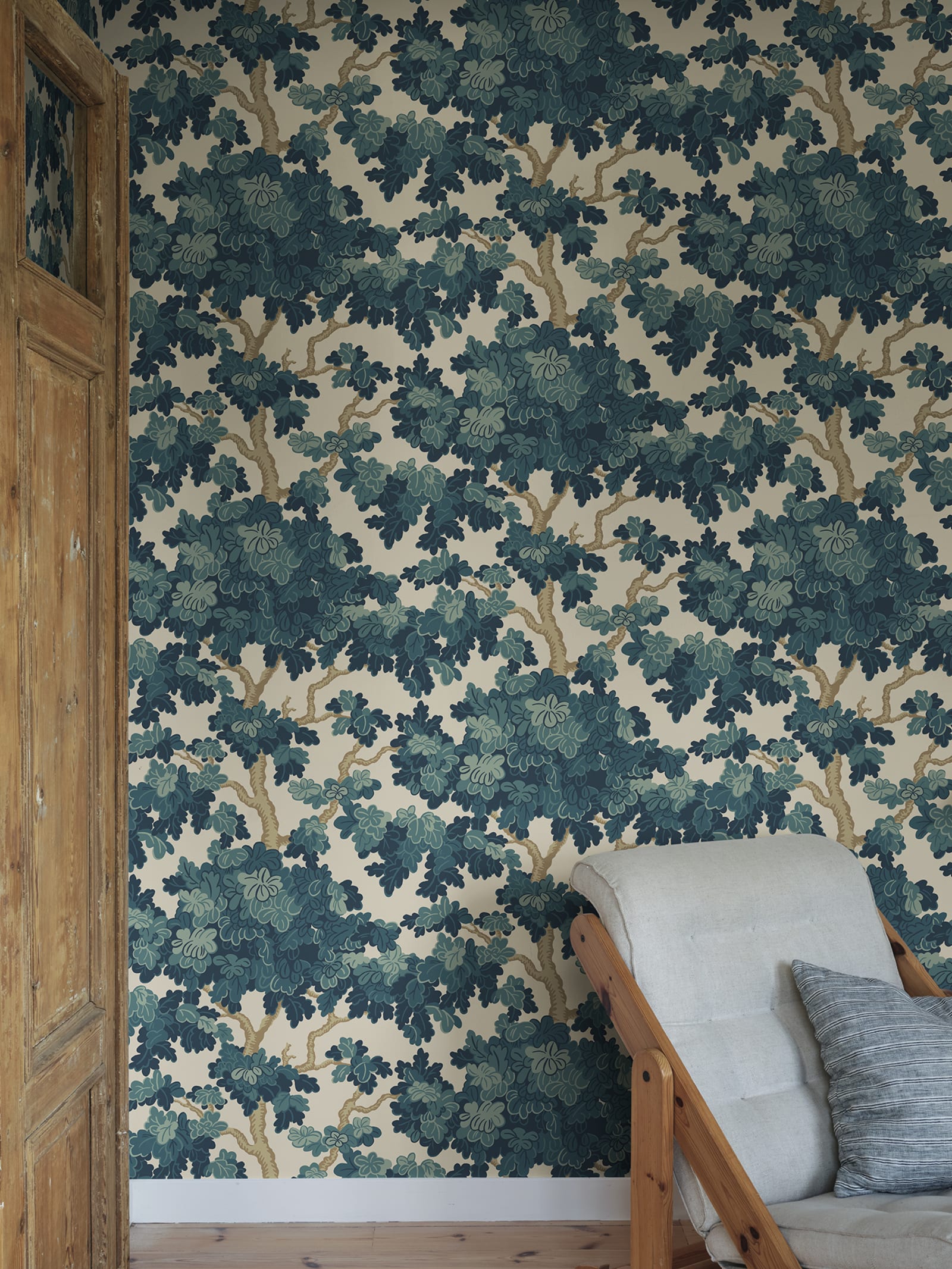 Eken wallpaper by Sandberg in teal-petrol green, styled beside a timber door with a linen armchair in the corner