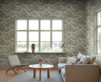 Eken wallpaper by Sandberg in sage green, styled in a living room around a large window with sofa, woven chair and arc lamp