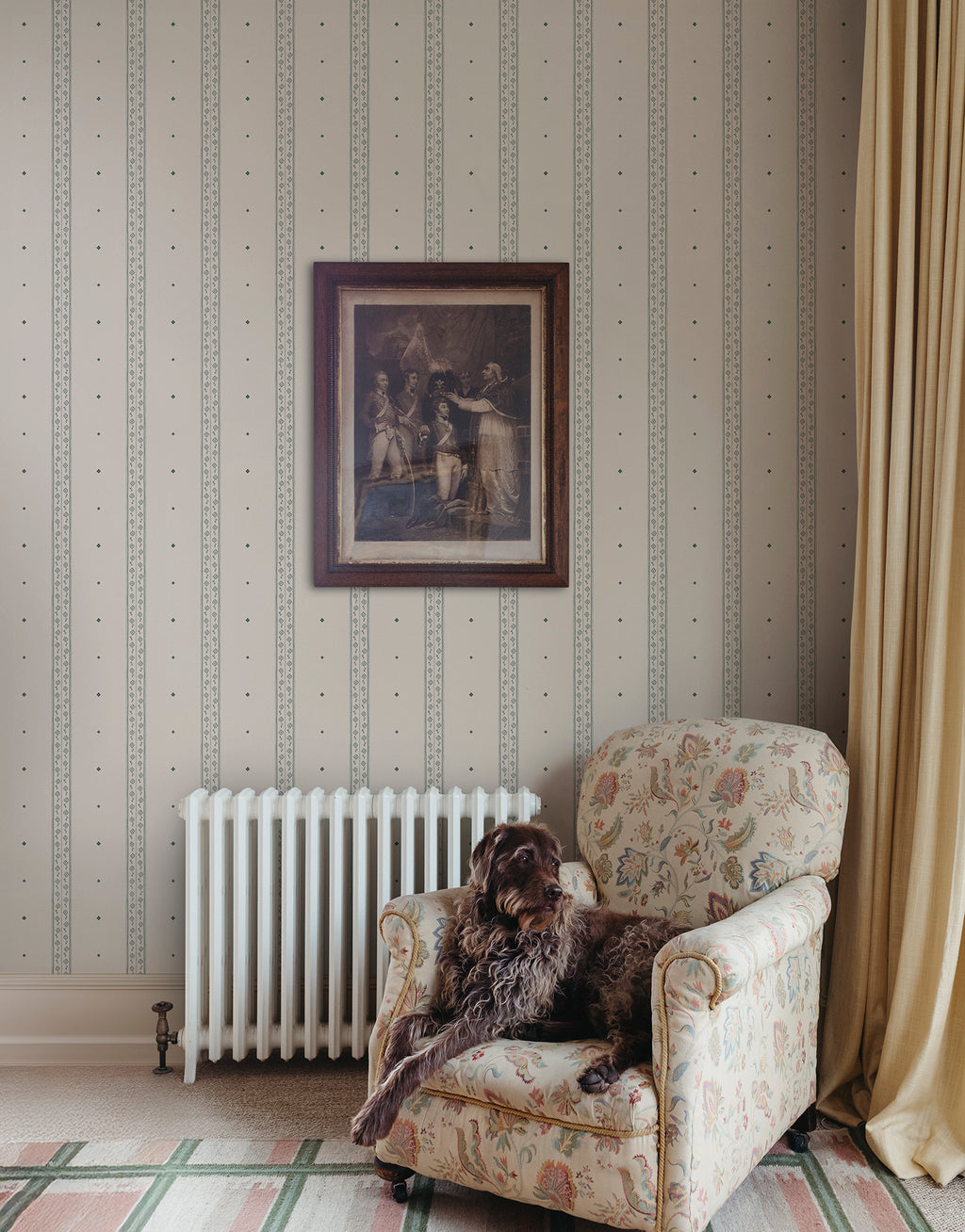 Austine wallpaper by Sandberg in Green beside an armchair and radiator with a framed print