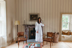 Austine wallpaper by Sandberg in Red in a light sitting room with a fireplace and tall window