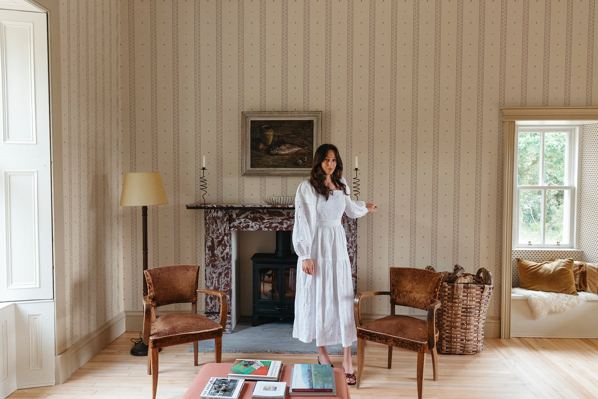 Austine wallpaper by Sandberg in Red in a light sitting room with a fireplace and tall window