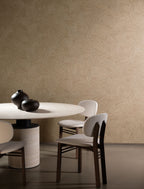 Mauna wallpaper by Arte in Beige – Indian River behind a round dining table and chairs