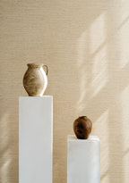 Motas wallpaper by Arte in Cream – Beach behind two vases on white plinths