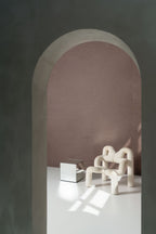 Motas wallpaper by Arte in Brown around an archway with a sculptural chair