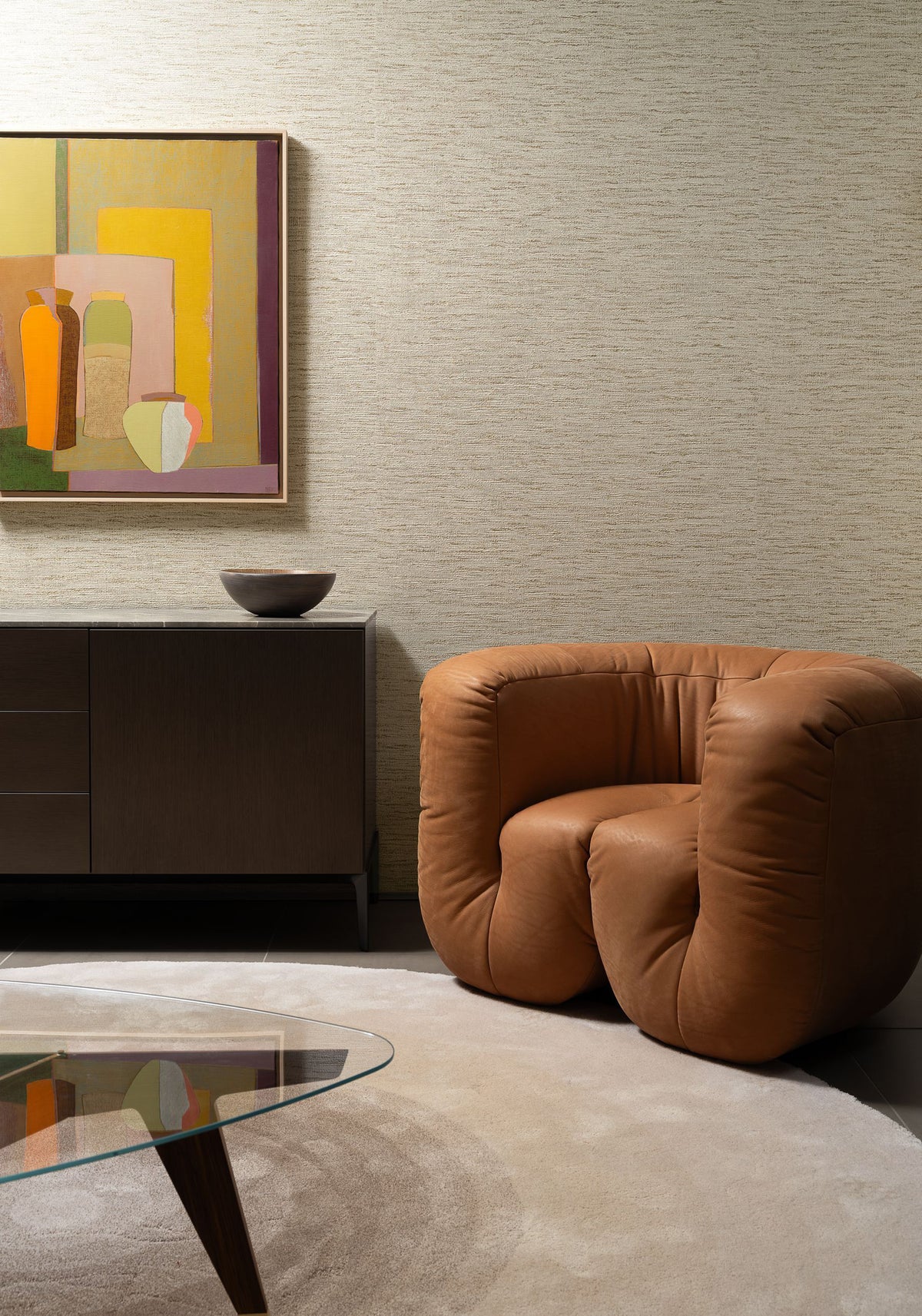 Ritorto wallpaper by Arte in Beige – Latte behind a tan leather armchair and a painting